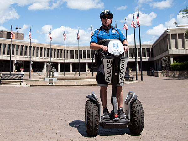 Policeman on Segway PT patroller in front of government building