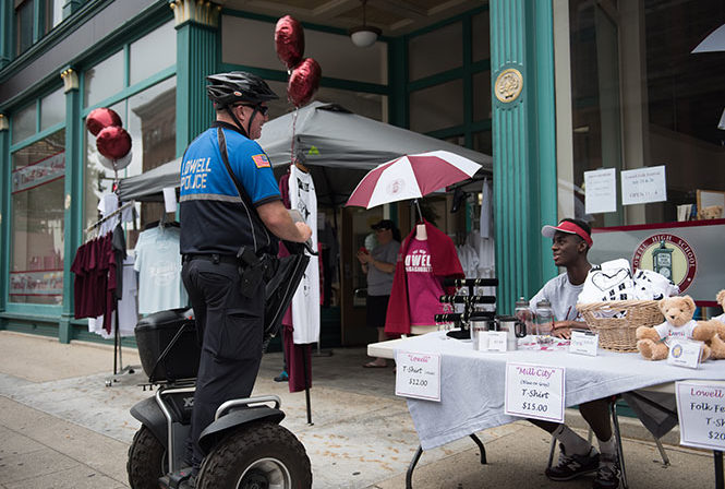 Lowell, MA policeman using Segway x3 SE PT Patroller while talking with local merchant